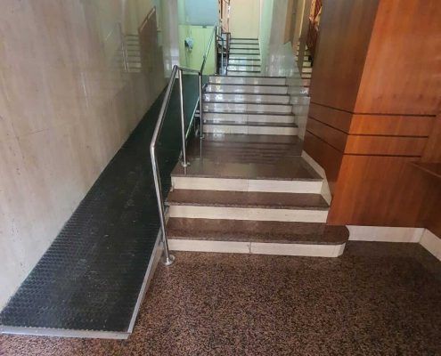 Rampa antigua con pendiente pronunciada y suelo de goma en un portal de Murcia antes de la reforma .