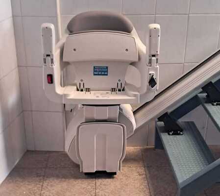 Silla salvaescaleras plegada para ahorrar espacio en el tramo de escaleras de una vivienda en Torreaguera